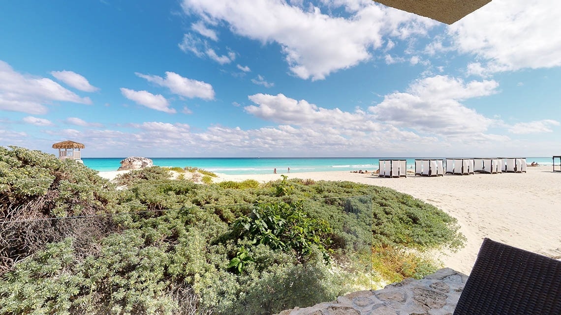 Perspectiva traseira da praia e camas balinesas no The Villas by Grand Park Royal Cancun