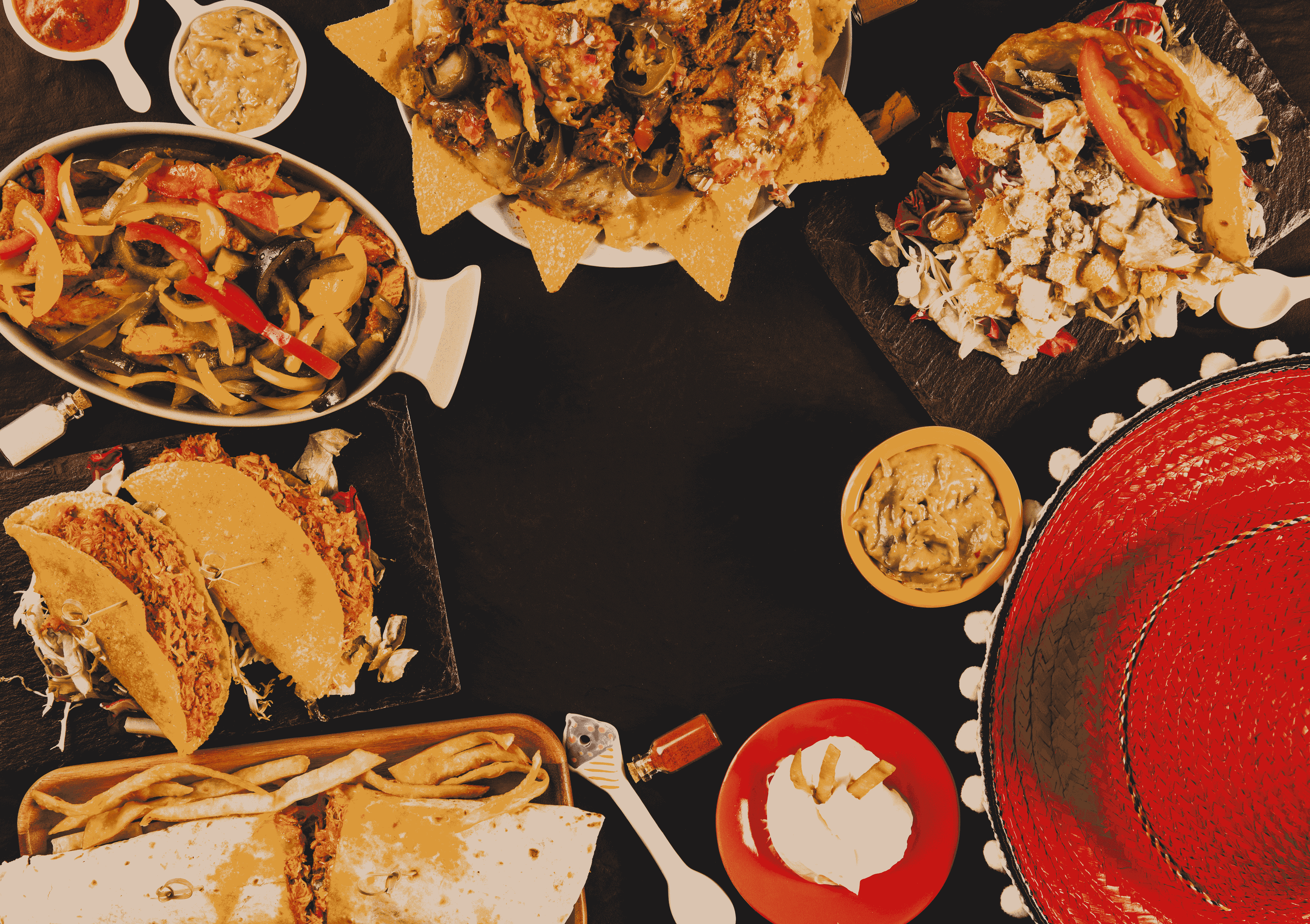 una mesa llena de platos de comida mexicana y un sombrero rojo