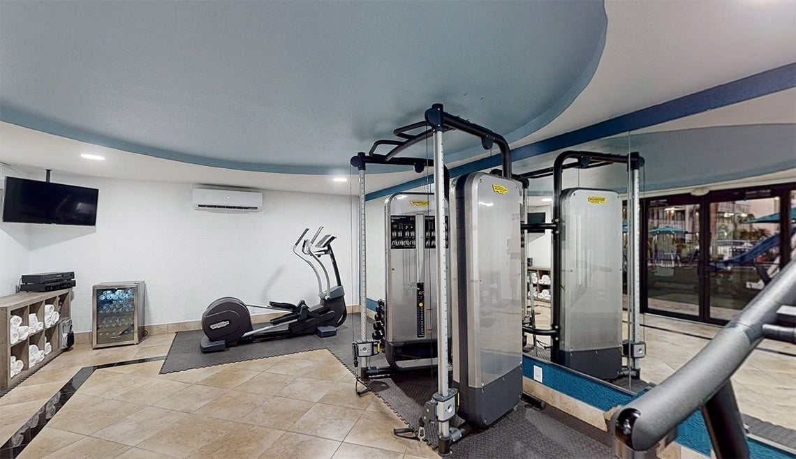 a gym with a few machines and a tv