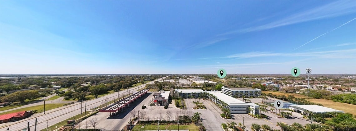 an aerial view of a city with a hotel and a gas station