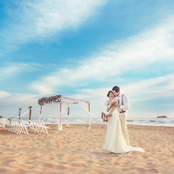 Casal de noivos celebrando seu casamento na praia do Hotel Park Royal Beach Huatulco