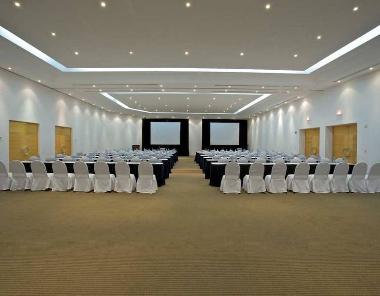 Panorámica de sala de eventos con sillas, atriles y TV de Park Royal hotels and resorts