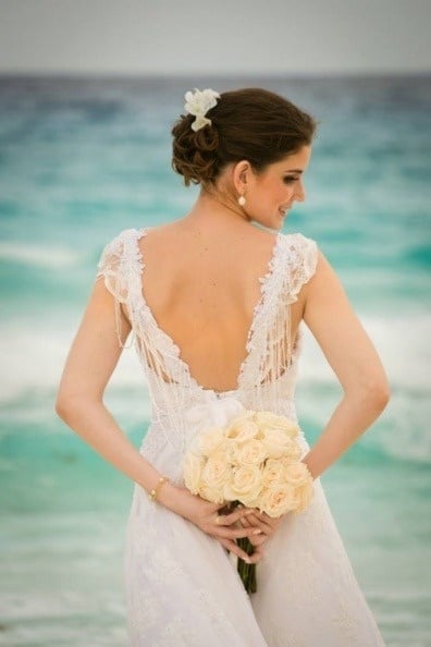 Noiva com buquê de flores na praia. Celebre o seu casamento no Hotel Grand Park Royal Cozumel