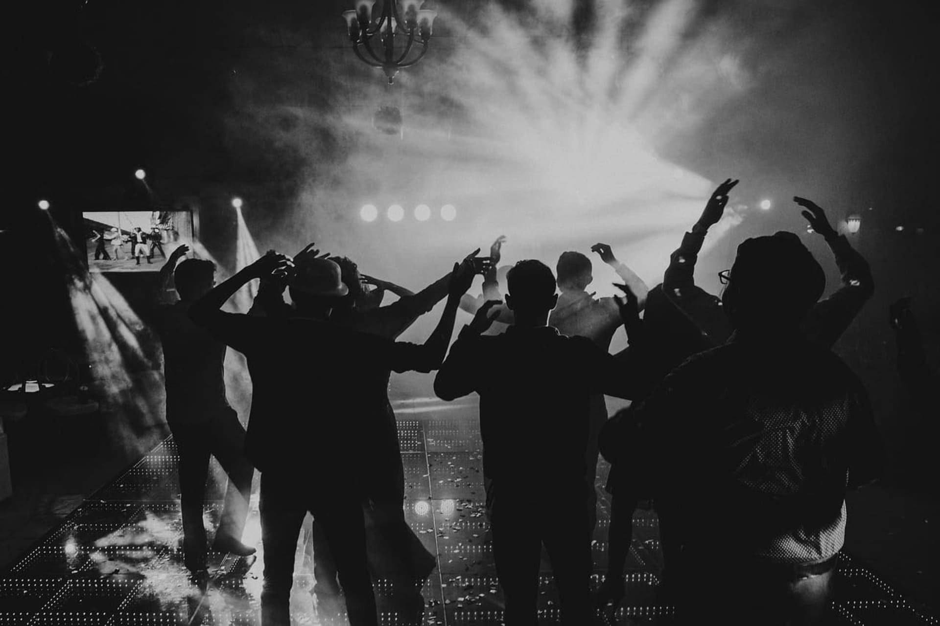 a group of people are dancing in a dark room