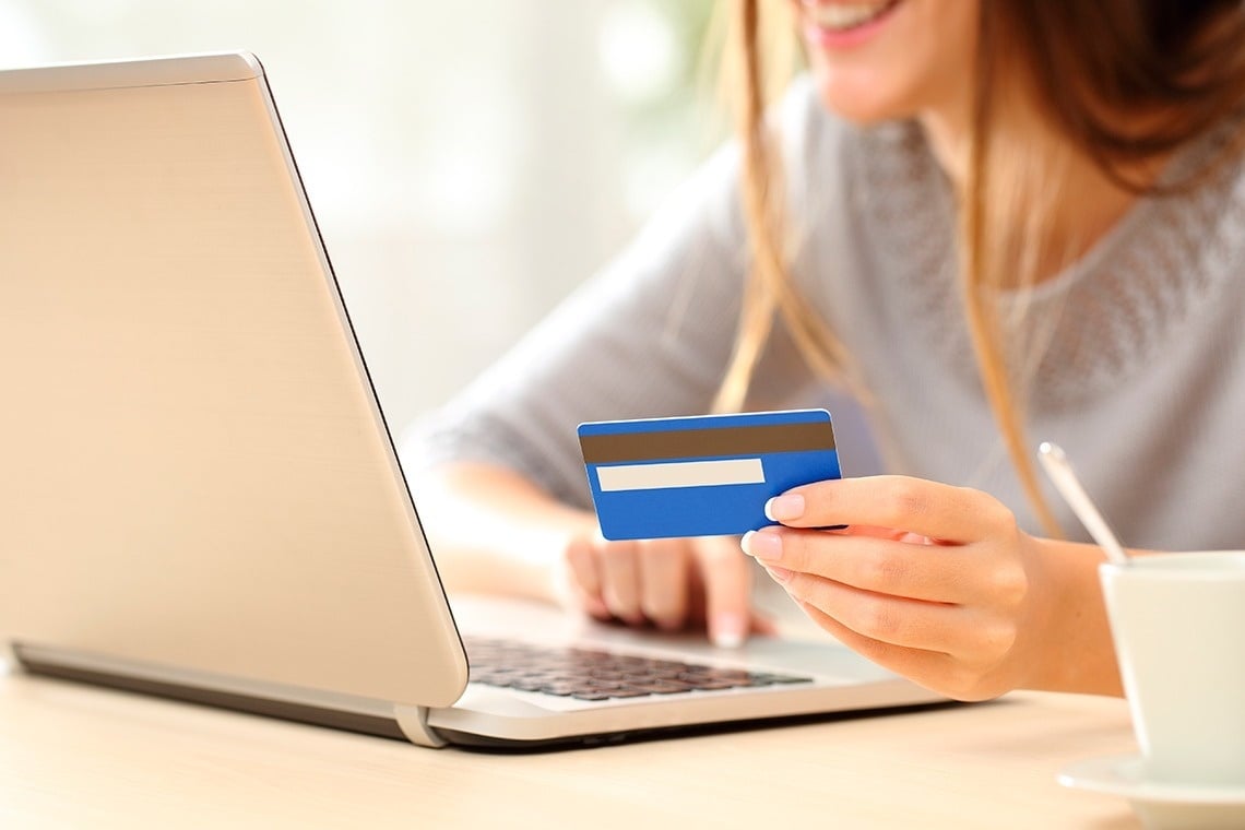 a person is holding a blue mastercard in their hand