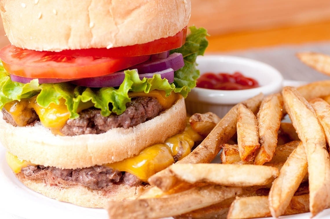 un primer plano de una hamburguesa y papas fritas en un plato