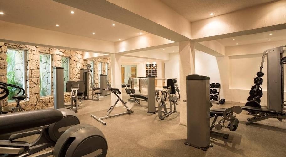 Training area with cardio machines and weights at the Grand Park Royal Cozumel Hotel