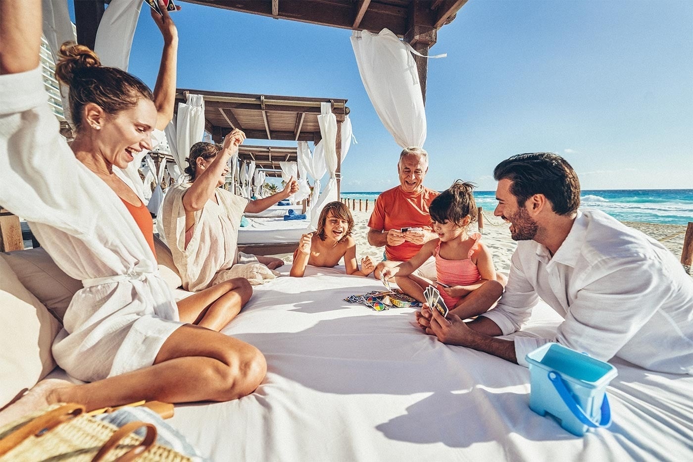 Familia jugando a las cartas en la playa, Hotel Grand Park Royal Cancún | Caribe Mexicano | Web oficial