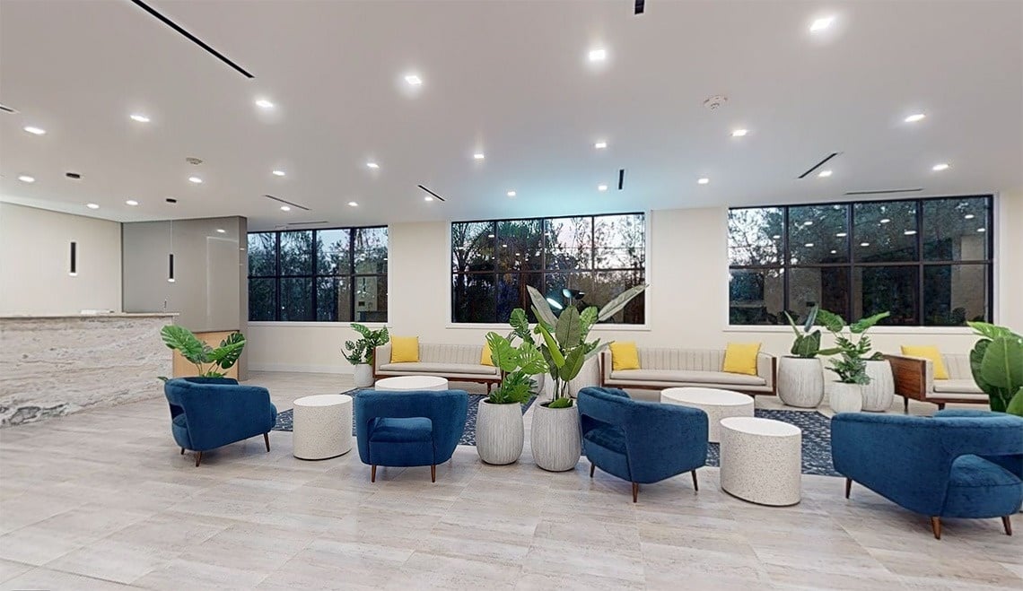 a lobby with blue chairs and a white couch