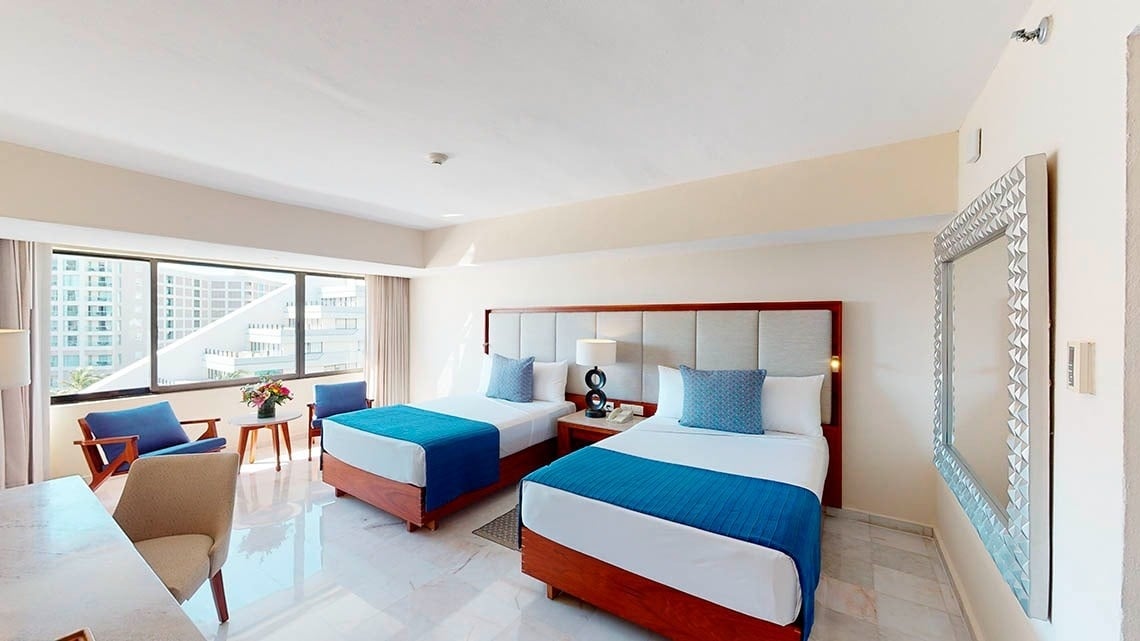 Quarto com duas camas e poltronas no Park Royal Beach Cancun Hotel