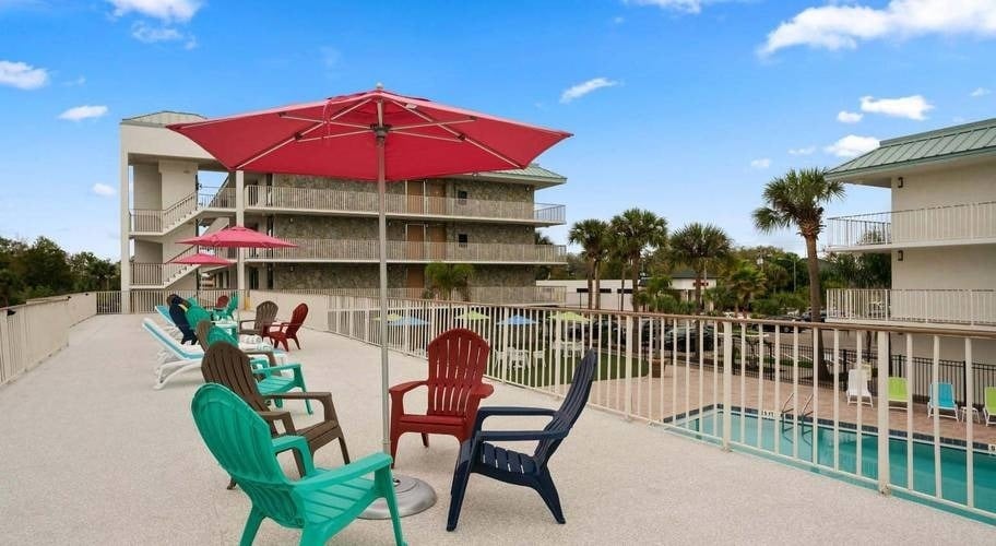 Terraza con sillas y mesas con vistas a la piscina en Park Royal Orlando, Florido