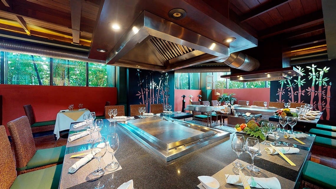 Chapa de cozinha cercada por mesas e cadeiras no Grand Park Royal Cancun Hotel