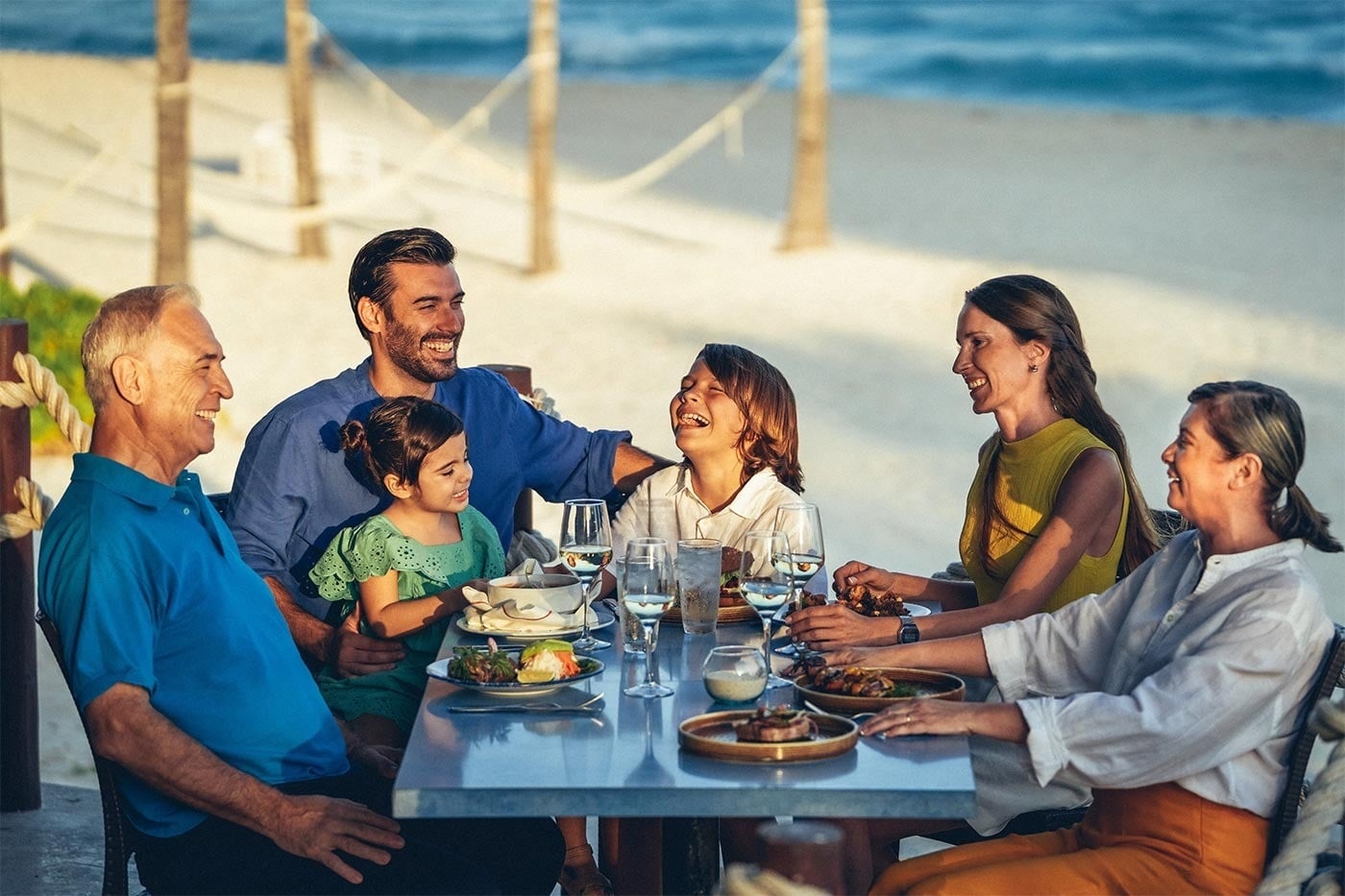 Familia disfrutando una cena en Park Royal: Cuerpo y mente relajados junto al mar.