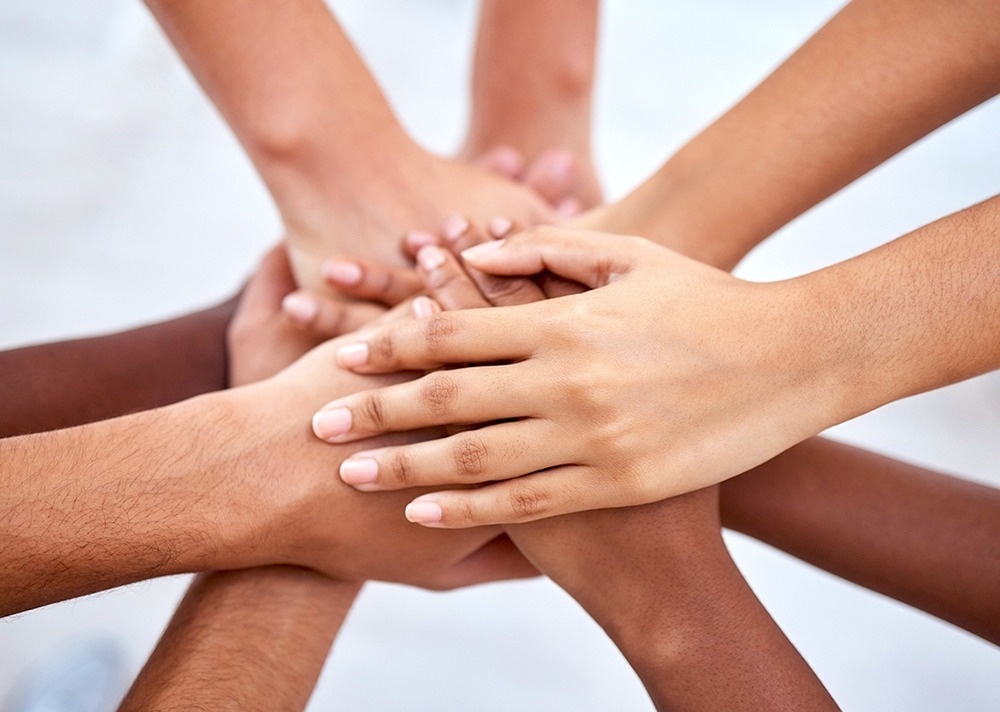 a group of people putting their hands together in a circle
