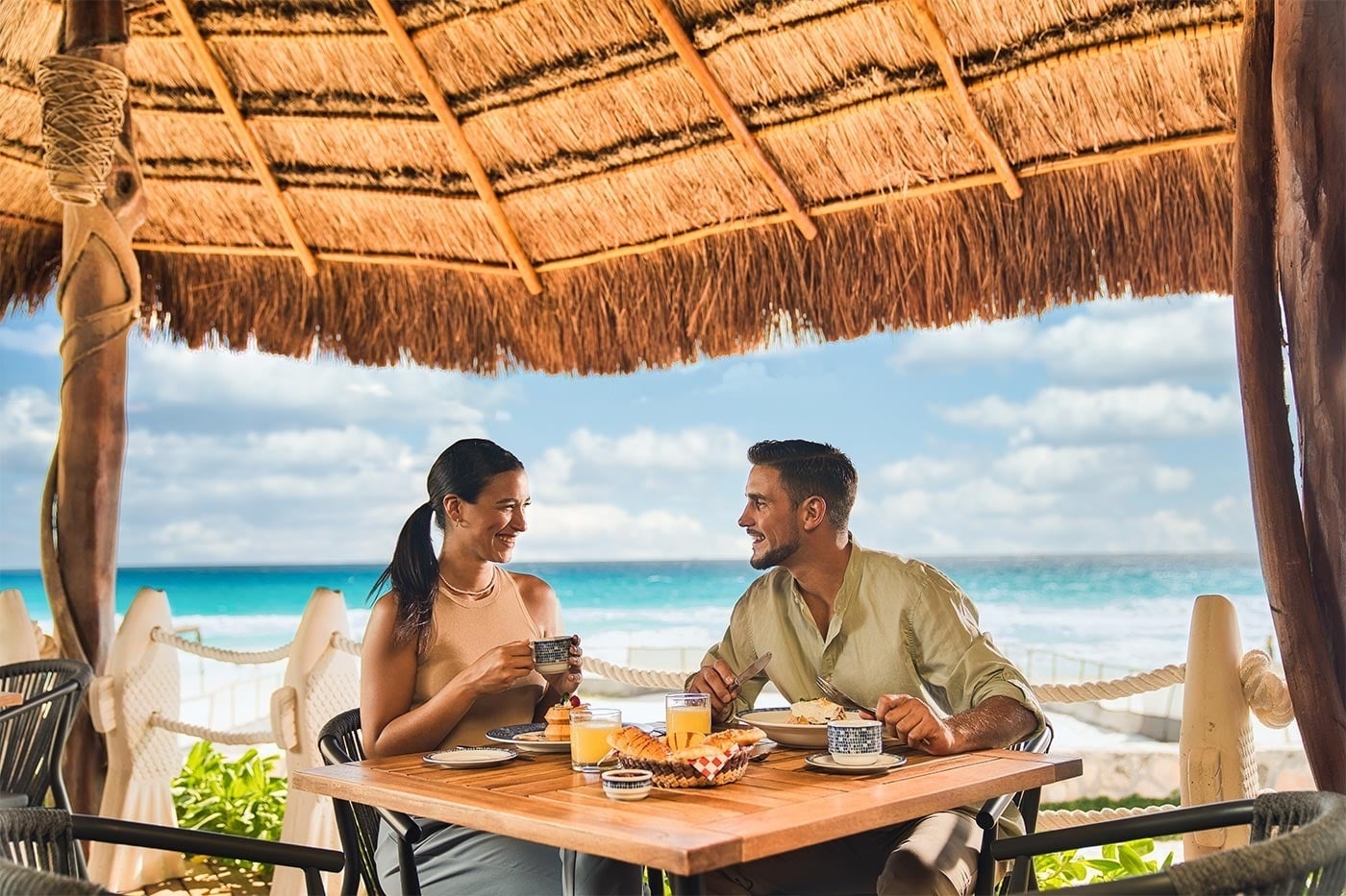 Couple enjoys breakfast with ocean view at Hotel Grand Park Royal Cancun, Mexican Caribbean.