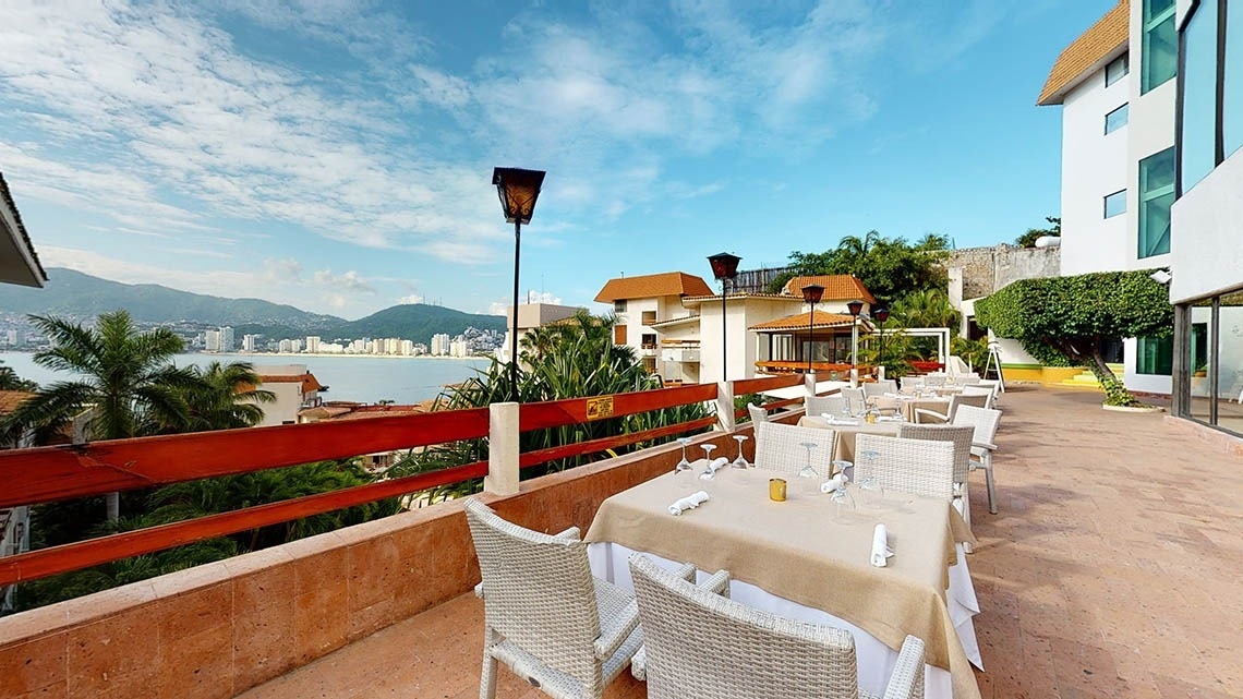 Terraço com mesas e cadeiras com vista para o mar do Hotel Park Royal Beach Acapulco