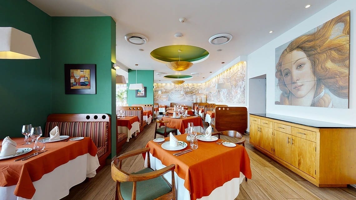 Restaurante Andiamo com mesas, cadeiras e luminárias decoradas com cores quentes do Hotel Grand Park Royal Puerto Vallarta