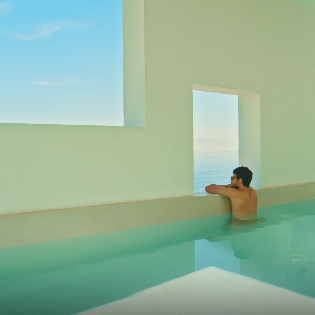 Hombre relajado en piscina de interior con ventanas en Park Royal hoteles y resorts