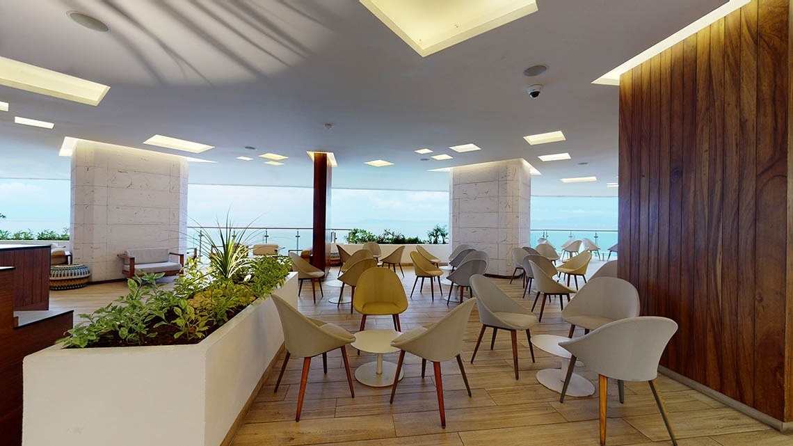 Zona de restaurante El Pescador con sillas y mesas con vistas al mar del Hotel Grand Park Royal Puerto Vallarta