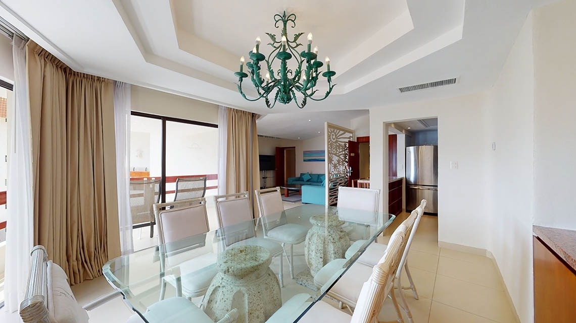 Sala de estar com mesas e cadeiras em um quarto do Park Royal Beach Acapulco Hotel