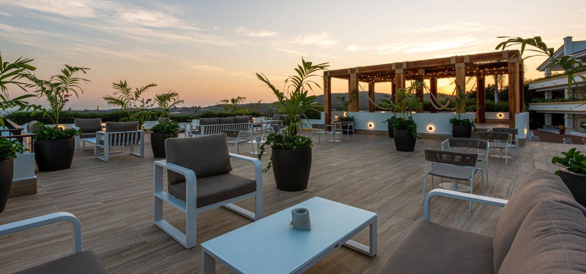 Terraço decorado com cadeiras, mesas e vasos do Hotel Park Royal Beach Huatulco