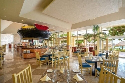 a restaurant with tables and chairs and a large watermelon on the ceiling .