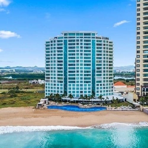 an aerial view of a large building on a beach next to the ocean .