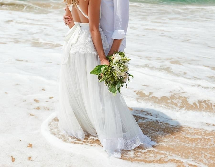 Noiva e noivo à beira-mar, molhando seu vestido e terno em Mazatlan, Pacífico mexicano
