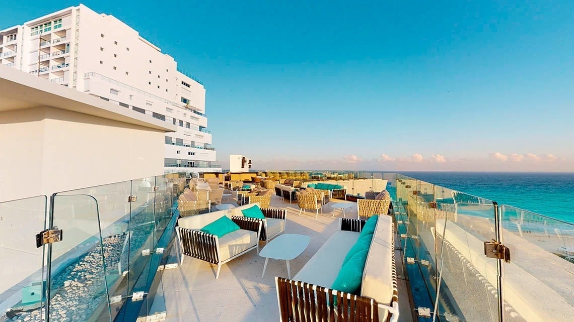 Terrace with armchairs and tables of the Ekinox Sky Bar of the Park Royal Beach Cancun Hotel