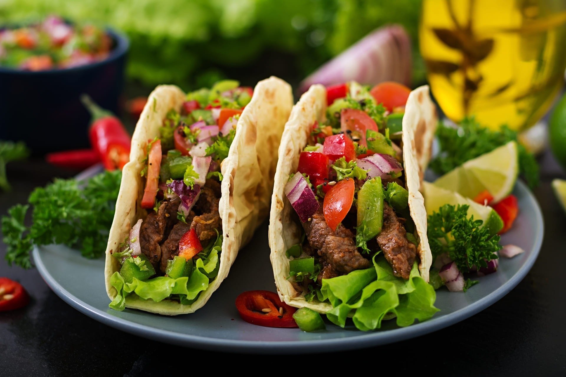 three tacos with meat and vegetables on a plate