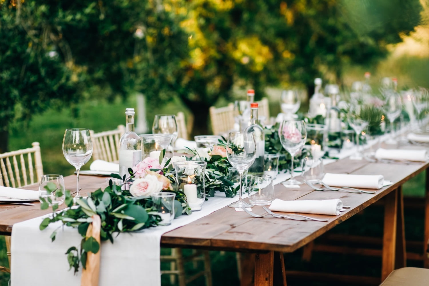 a long wooden table set for a wedding reception