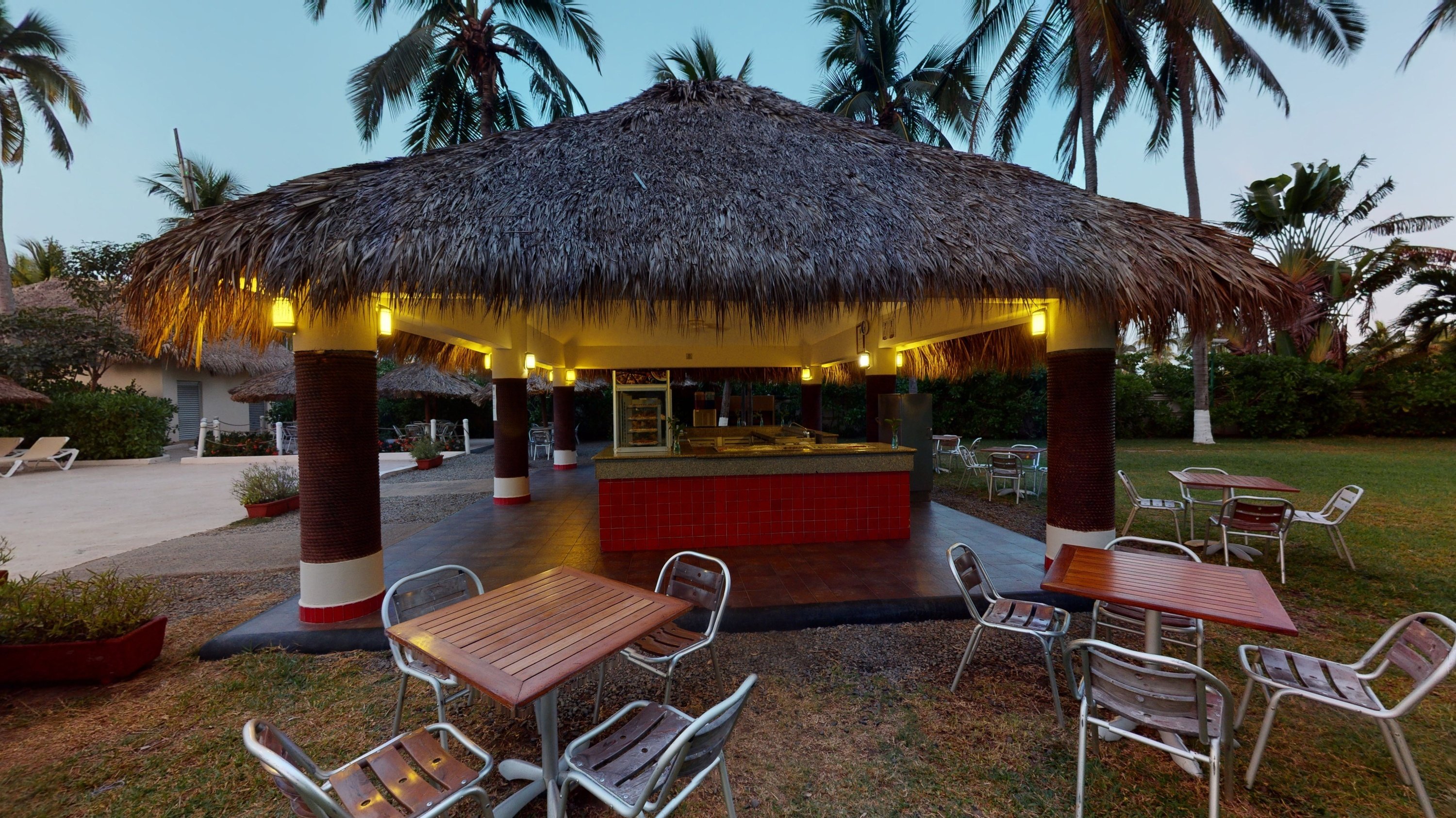 Family eating a snack at a palm-thatched bar at Park Royal Beach Ixtapa, Mexico