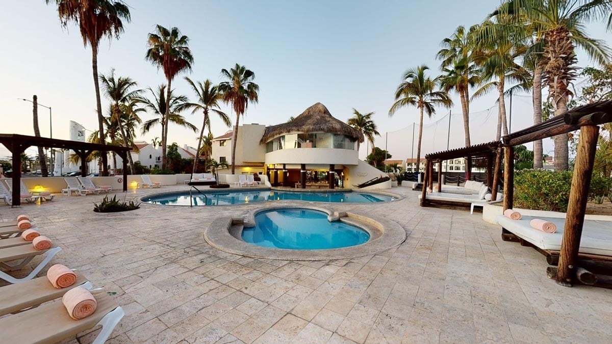 a large swimming pool with a hot tub in the middle