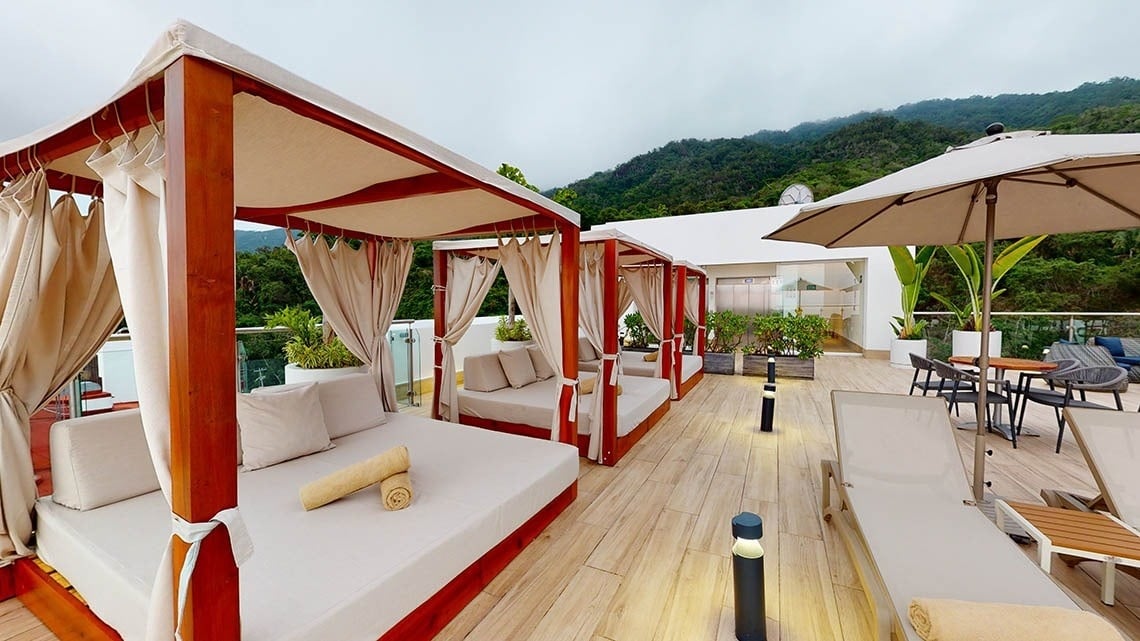 Área de relaxamento, com camas balinesas, redes e poltronas com mesas no Hotel Grand Park Royal Puerto Vallarta