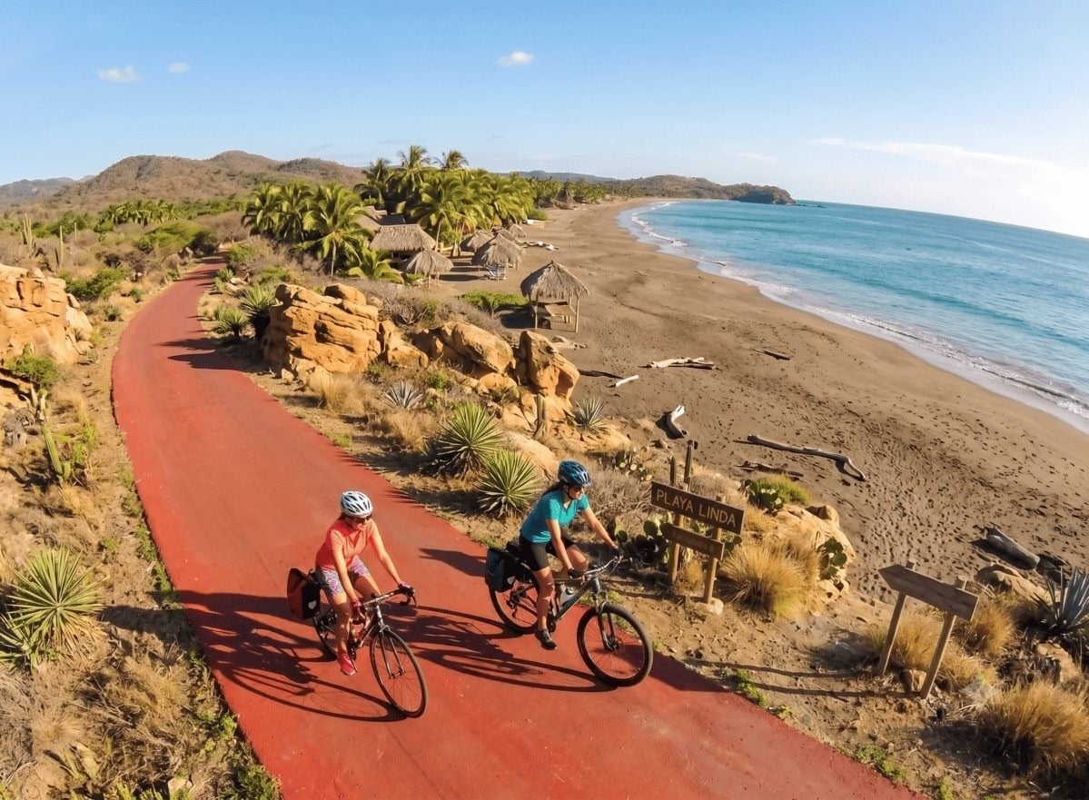 Ciclistas de Park Royal en sendero rojo junto a playa