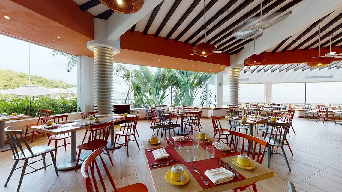 Mesas de restaurante decoradas com vista para o mar do Hotel Grand Park Royal Puerto Vallarta