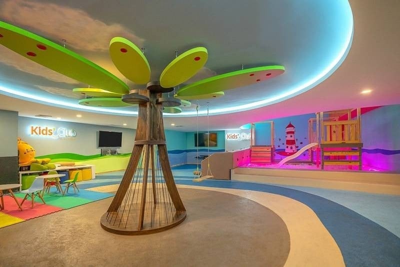 Sala de juego para niños, Kid´s Club, con una palmera como columna en Grand Park Royal Cancún