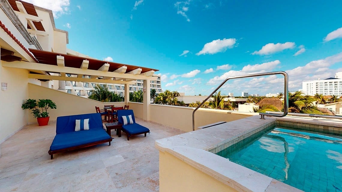 Terraço com mesas, cadeiras, sofás e piscina privativa do Grand Park Royal Cancun Hotel