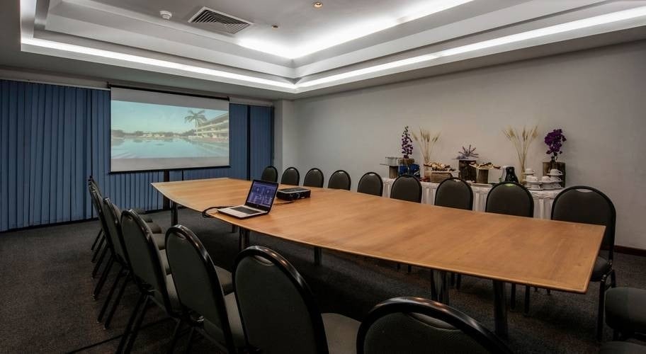 Sala de eventos com TV plana, mesa grande com cadeiras no Park Royal Beach Huatulco Hotel