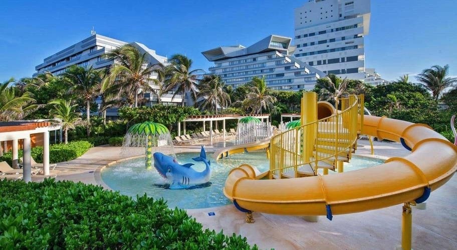 Piscina con toboganes, sombrilla de agua y tiburón en el Hotel Park Royal Beach Cancún