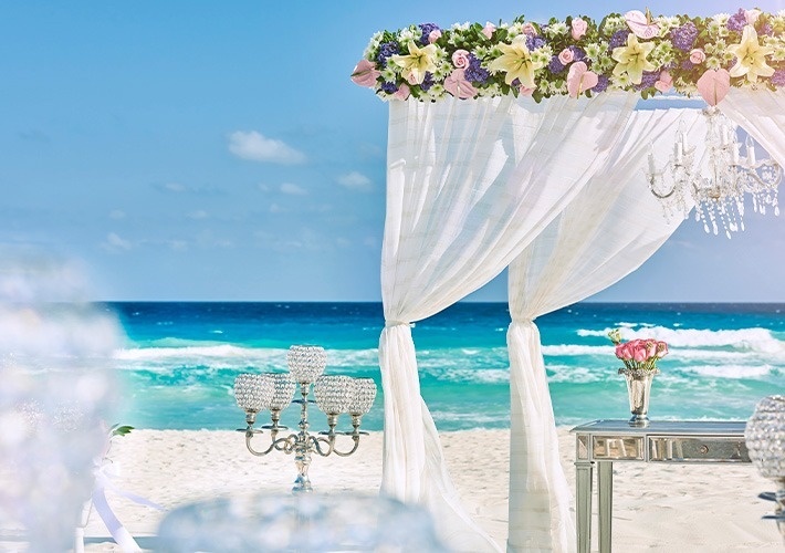 una boda en la playa está decorada con flores y candelabros