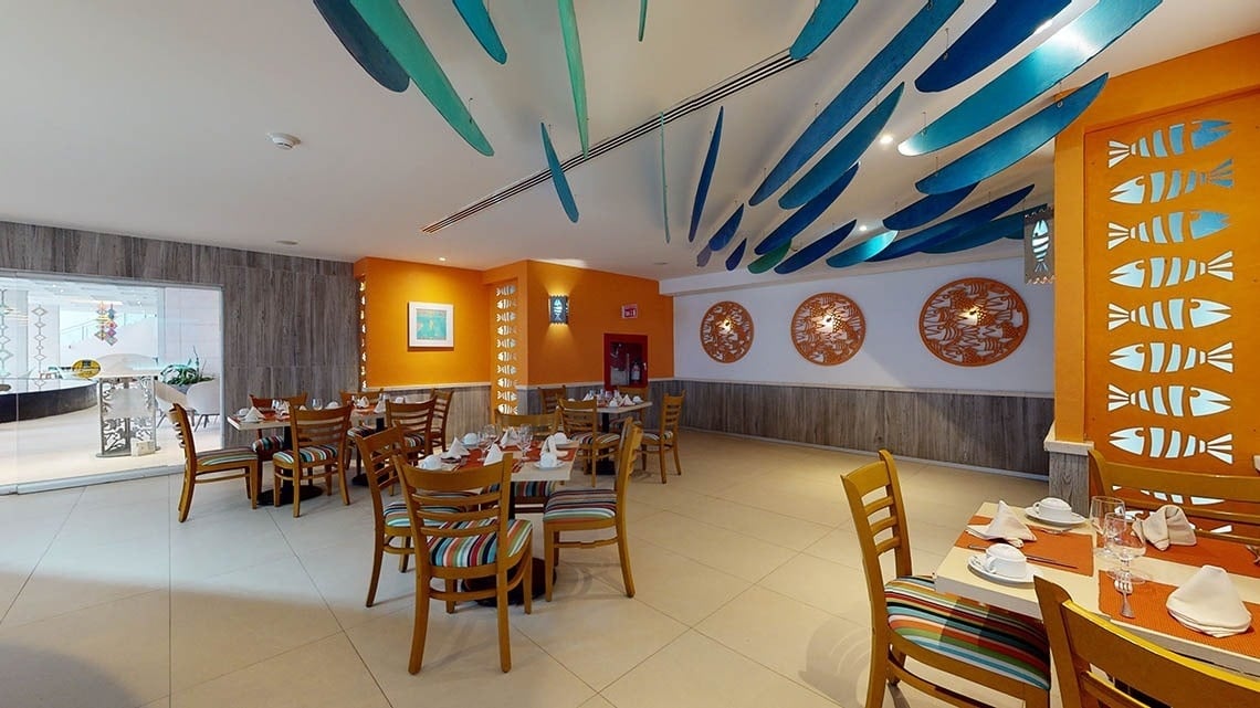Grande área de mesas e cadeiras no restaurante El Pescador do Hotel Grand Park Royal Puerto Vallarta