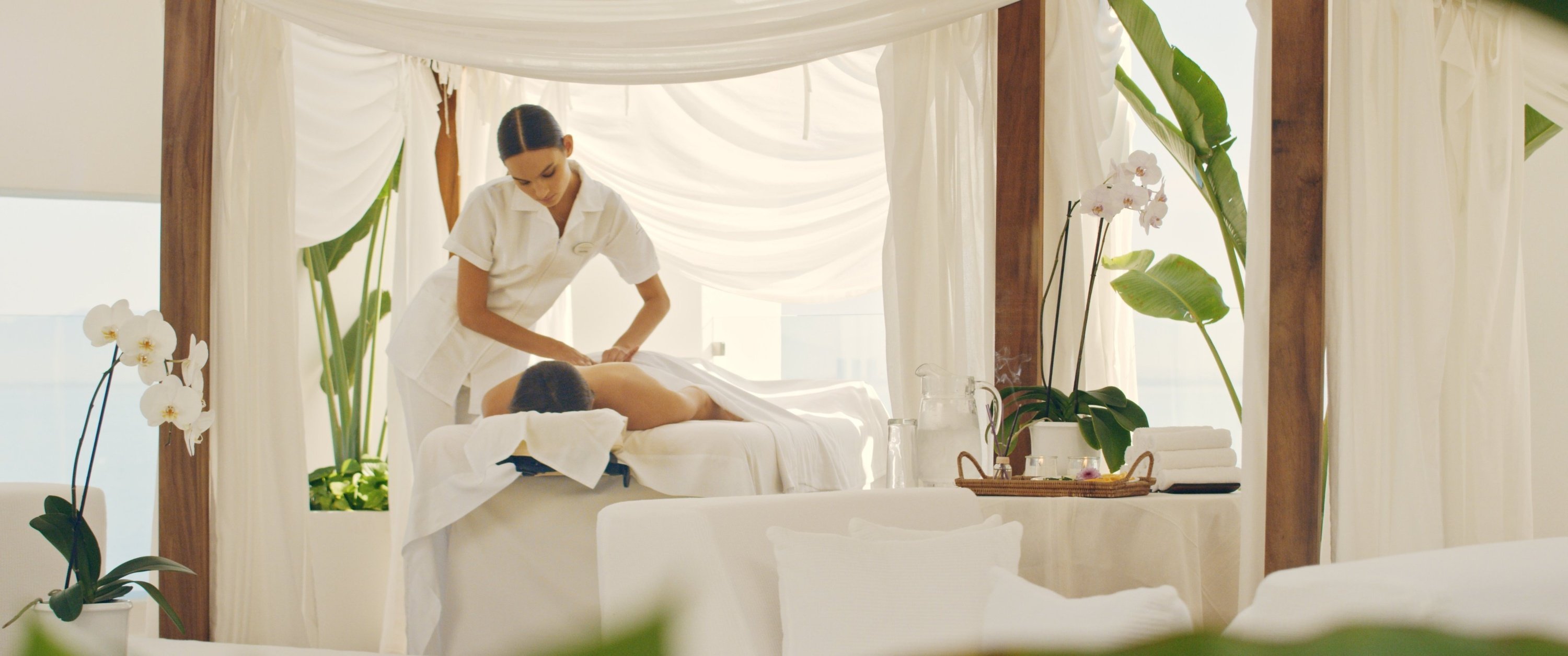 Mulher recebendo uma massagem na área de bem-estar do Grand Park Royal Cozumel Hotel