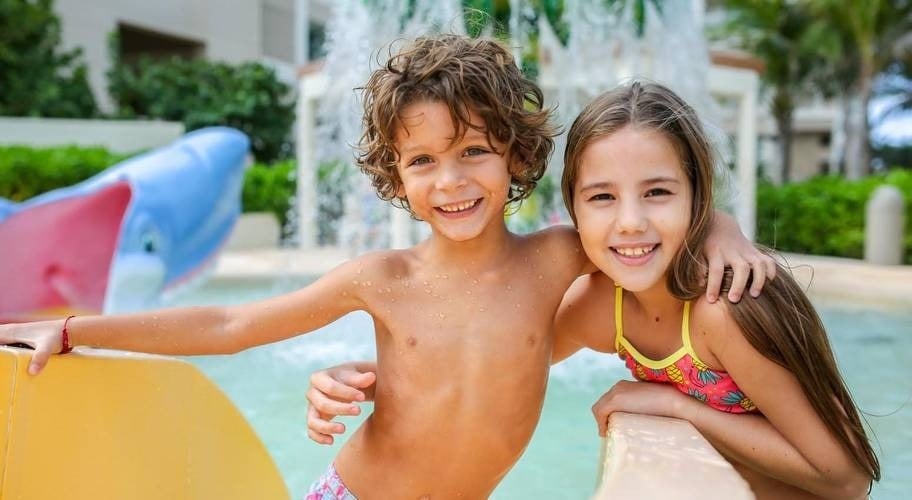 Menino e menina se divertindo no parque aquático do Park Royal Beach Cancun Hotel