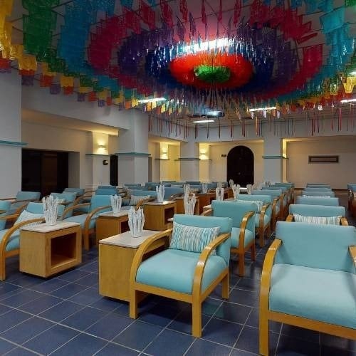 a row of chairs in a room with a colorful ceiling