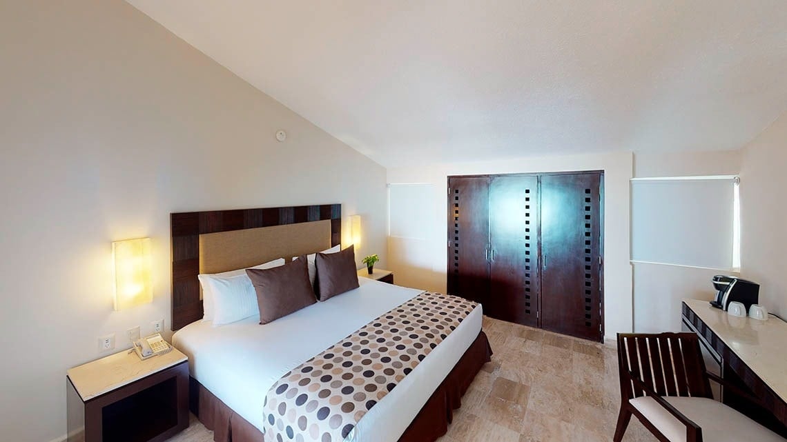 Quarto com cama king size e escrivaninha no Grand Park Royal Cancun Hotel