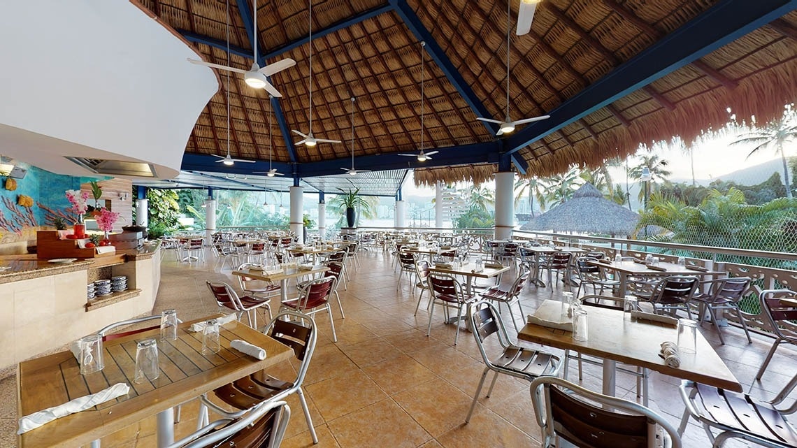 Área de mesas e cadeiras do restaurante El Pescador no Park Royal Beach Acapulco Hotel