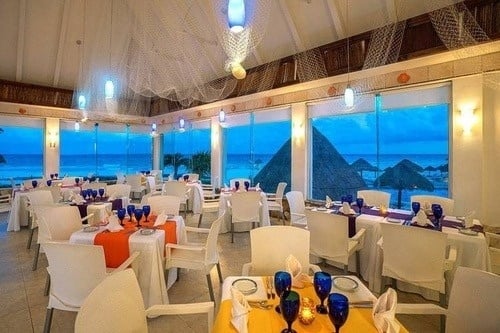 a restaurant with tables and chairs set up and a view of the ocean .