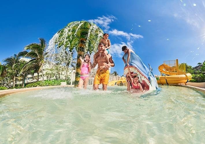 uma família está brincando em uma piscina em um parque aquático .