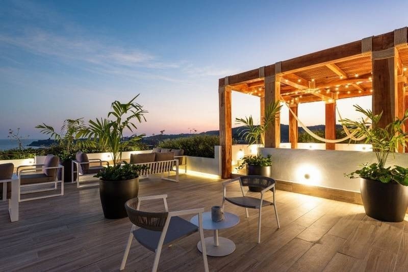 Terrace with tables, chairs and plants overlooking the sea of the Hotel Park Royal Beach Huatulco